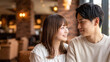 © Jesse_4160 - Young Asian couple in love smiling and looking at each other in a cozy cafe setting, romantic date atmosphere