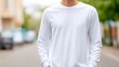 © evgenia_lo - Young man confidently standing on a suburban street wearing a simple white long-sleeve shirt, showcasing a casual and relaxed atmosphere in an outdoor setting