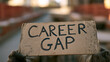 © photo for everything - Person holds a cardboard sign with 'CAREER GAP' written on it, highlighting unemployment or a break from professional life in an urban setting