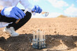 © Serhii - Agronomist scientist analyzing soil in field for research