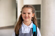 © Ladanifer - Young girl student smiling at campus wearing school uniform and backpack