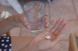 © Adrián - Close-up of female hands taking pills from a blister pack, pharmaceutical treatment concept.