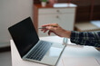 © Tj - Professional hand holding a pen, pointing at a laptop screen, discussing business data, financial reports, or project information in an office or home workspace