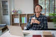 © Tj - Mature man taking a moment of relaxation and peace at his home office desk, holding a cup of coffee and closing his eyes, enjoying a mindful break from work