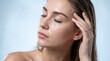 © Nova Craft - Serene young woman with dewy moist skin touching her wet hair against soft blue background with displays close up portrait woman her eyes closed