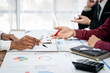 © Freedomz - A group of people are sitting around a table with papers and pens
