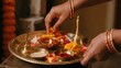 © viperagp - Woman arranges marigolds around glowing diya on traditional Diwali puja tray indoors