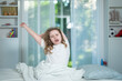 © Volodymyr - Morning wake feels sleepy and relaxed. Morning routine starts with yawning. Young girl feels morning tiredness. Bright bedroom supports morning wakefulness.