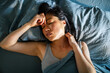 © Davor - Tired woman with headache resting in bed at home