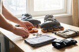 Person organizing rollerblades and spare wheels on a wooden workbench