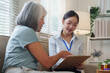 © Natee Meepian - Asian female nurse explaining medical documents to senior woman at home checkup