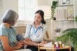 © Natee Meepian - Asian nurse checking senior woman blood pressure at home for senior healthcare checkup