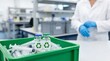 © MdNazim - A green plastic crate containing glass medical vials with green recycling symbols and syringes in a laboratory setting with a scientist nearby