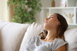 © PheelingsMedia - Apathetic woman looking away on a couch at home