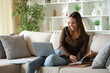 © PheelingsMedia - Happy teleworker taking note checking laptop working