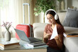 © PheelingsMedia - Tele worker showing indorm in a video call during business travel