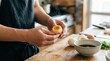 © wahid - Chef peeling a soft boiled egg for ramen in a bright home kitchen