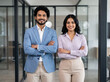 © Someone Cooked Here - young Indian businesswoman and businessman with crossed arms in premium corporate office for leadership teamwork management and business success
