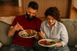© La Famiglia - Couple enjoying asian food with chopsticks at home