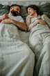 © La Famiglia - Happy couple relaxing in bed laughing together