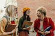 © La Famiglia - Diverse students laughing together on university campus