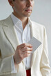 © Pixel-Shot - Man in a cream suit holding a blank white card, business and identity concept, professional presentation