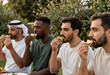 © Pixel-Shot - Diverse group of men enjoying a meal outdoors, sharing food and conversation in a relaxed setting, the men are seen eating small portions of food