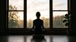© Luan - Silhouette of a woman practicing yoga meditation in a peaceful room with large window