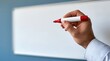© dmmarychev - Close up of hand holding red marker against blank whiteboard