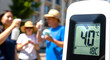 © Rinda - Group of people holding spray bottle  during extreme heatwave warning