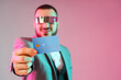 © Pixel-Shot - Young businessman in AR glasses with credit card on grey background. Online banking concept