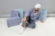 © Pixel-Shot - Stylish young man with shopping bags sitting on color background