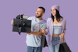 © Pixel-Shot - Young couple with shopping bags and gift on lilac background. Cyber Monday