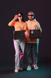 © Pixel-Shot - Young couple in VR glasses with shopping bags on dark background. Cyber Monday