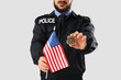 © Pixel-Shot - Police officer with badge and USA flag on light background, closeup. Labor Day celebration