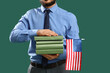 © Pixel-Shot - Male teacher with USA flag and books on green background. Labor Day celebration