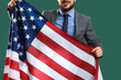 © Pixel-Shot - Young businessman with USA flag on green background. Labor Day celebration