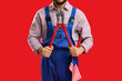 © Pixel-Shot - Male worker with pipe wrench and USA flag on red background. Labor Day celebration