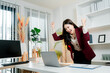 © Daenin - Young asian businesswoman celebrating achievement and success while looking at her laptop screen, feeling happy and excited in a modern home office environment