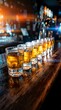 © Yuliia - Row of whiskey or bourbon shots lined up on wooden bar counter with warm golden lighting and blurred bar background, suitable for hospitality, nightlife, and beverage industry content.
