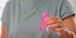 © Natee Meepian - Hand holding pink ribbon for breast cancer awareness and healthcare support