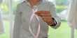 © Natee Meepian - Hand holding out pink ribbon for breast cancer awareness and healthcare campaign