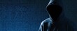 © oksa_studio - Hacker in a hoodie standing before digital binary code for cyber security privacy