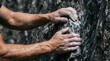 © Dragonboyr - Strong chalked hands hold tightly onto a rough dark granite surface during a climb.