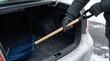 © SimpleDesignStudio - Person holding a snow shovel taking it out from the trunk of a car during winter