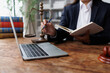 © groviapoto - Lawyer working on legal research and planning with laptop, scales of justice, and law books in office