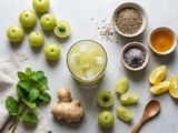 Fresh amla juice in a glass with ginger mint and indian gooseberry fruits on a table. Aamla juice recipe