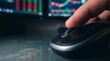 © KinanZ - Close up of hand on mouse with trading charts