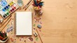 © Darakorn - Top view flat lay of blank open sketchbook surrounded by art supplies watercolor set colored pencils and cute woodland animal stickers on wooden desk with copy space.