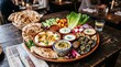 © SyedaMahfuja - Middle Eastern mezze platter with hummus, pita bread, and fresh vegetables on rustic table